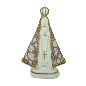 A imagem de Nossa Senhora Aparecida é toda trabalhada de forma artesanal e com renda aplicada por todo manto